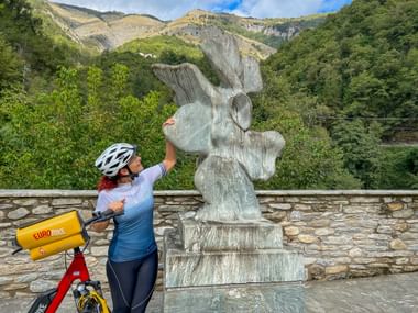 Radfahrerin blickt auf Skulptur