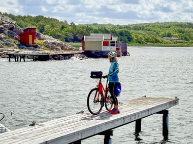 Radfahrerin mit Leihrad auf Steg am Hafen von Särö