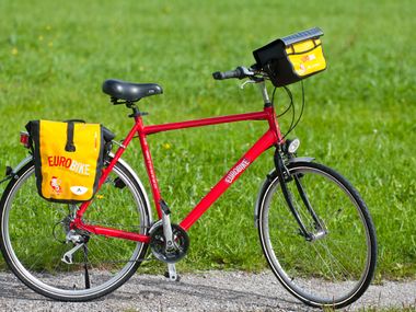 Ein rotes Fahrrad mit gelben Satteltaschen