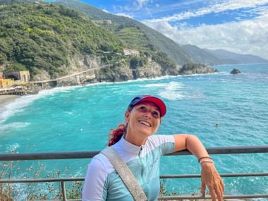 Glückliche Radfahrerin mit Meer im Hintergrund