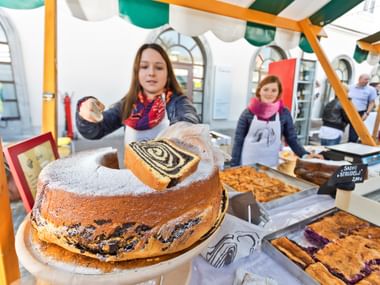 Frau verteilt Potica an einem Marktstand