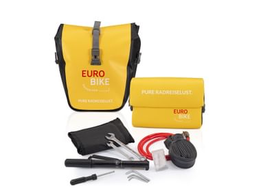 Yellow Eurobike panniers and handlebar bag with cycling repair kit including pump, wrenches, Allen keys, inner tube, and cable lock on white background.