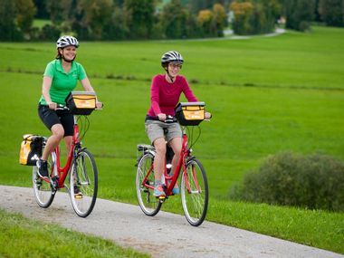 zwei Radler am Radweg im Grünen