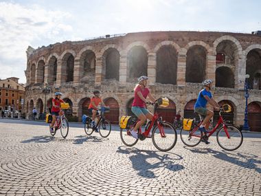 Group of cyclists in front of the Arena in Verona