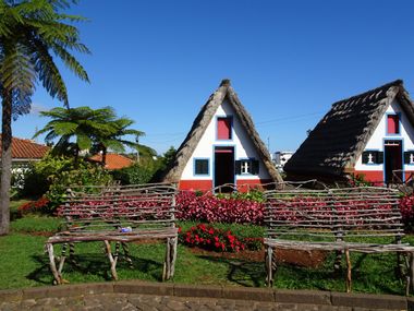 Wooden benches in front of colourful huts