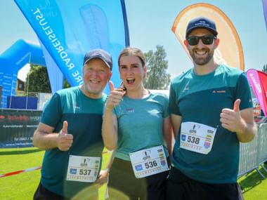 Three runners in turquoise Vaude shirts with race bibs 537, 536, and 538 giving thumbs up at Grabenseelauf 2026 finish area.