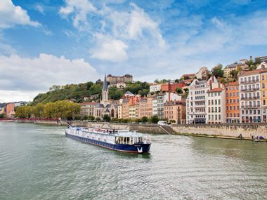 View of a passenger ship, with the city of Lyon in the background