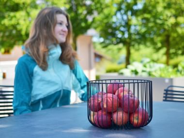 Obstkorb mit Mitarbeiterin im Hintergrund