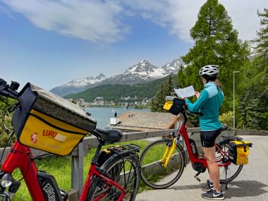 Cyclist with route book with a view of St. Moritz