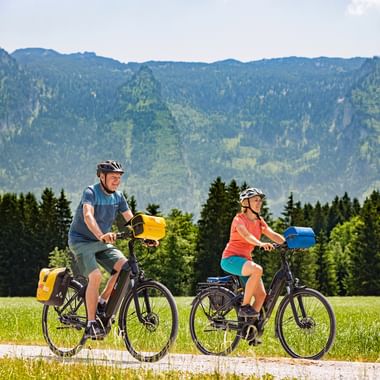 Cyclist couple in front of a mountain backdrop in the countryside