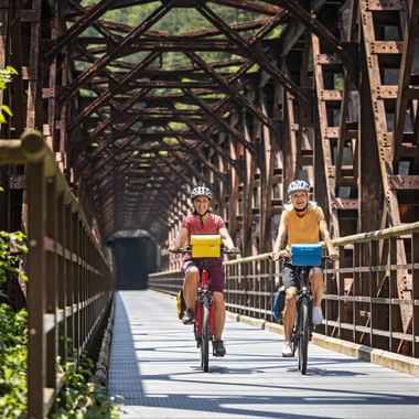 Two cyclists on the Ponte di Ferro in the Canal Valley