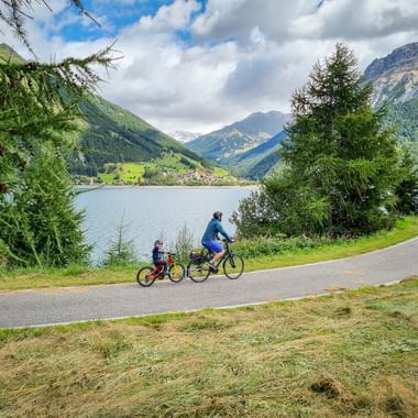 Cycle path at Lake Reschen with a view of Graun Cycle path at Lake Reschen with a view of Graun