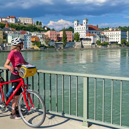 Radfahrstopp auf einer Brücke mit Blick auf die Donau und Passau
