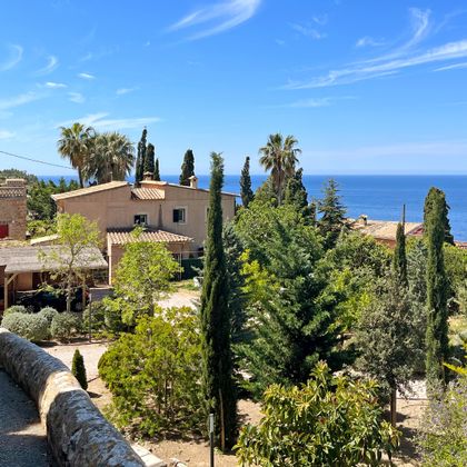 View over typical Mallorcan houses and gardens to the sea