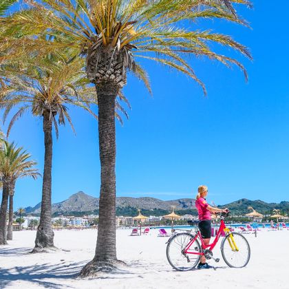Radfahrerin am Strand von Port Alcudia