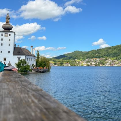 Cyclist looks at Ort Castle on Lake Traunsee