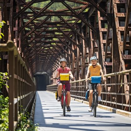 Two cyclists on the Ponte di Ferro in the Canal Valley