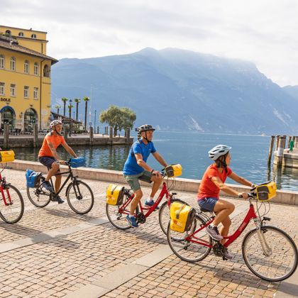 Gruppe von Radfahrern im Zentrum von Riva del Garda mit Seeblick