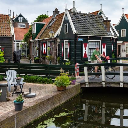 Cyclists on a small bridge over a canal in the historic town of Volendam