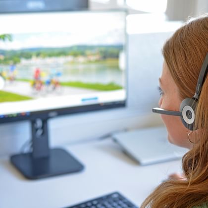 Employee with headset in front of computer