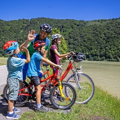 Family by the lake, father gives child high five