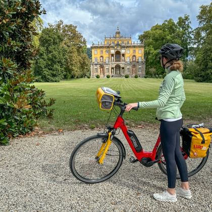 Radfahrerin steht vor der Villa Torrigiani