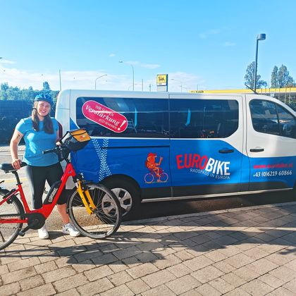 Radfahrerin mit E-Bike vor Eurobike-Bus