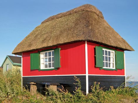 Haus mit Reetdach an der Küste