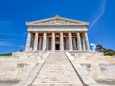 Walhalla-Gedenkstätte mit klassischer griechischer Tempelarchitektur, weißen Säulen und dreieckigem Giebel, erreichbar über breite Steintreppen.