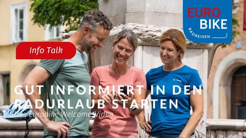 Drei lächelnde Personen schauen auf ein Smartphone auf einem Stadtplatz. Text 'Info Talk' und 'Gut informiert in den Radurlaub starten'. Eurobike-Logo sichtbar.