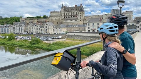 Paar mit Fahrrad blickt auf Schloss Amboise