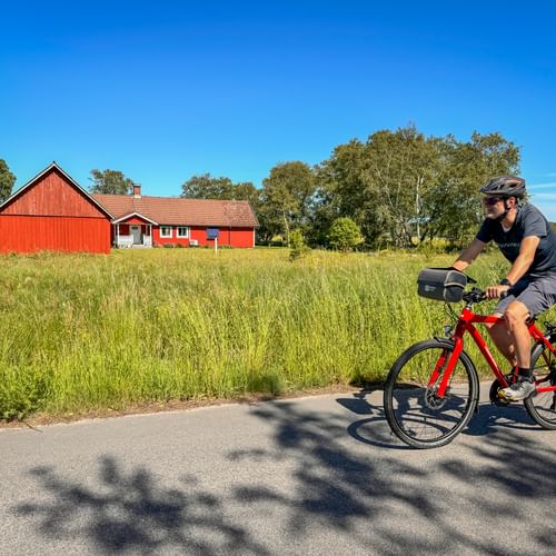Cyclist on the Kattegattleden near Hjortsberg - with a typical red Swedish house in the background