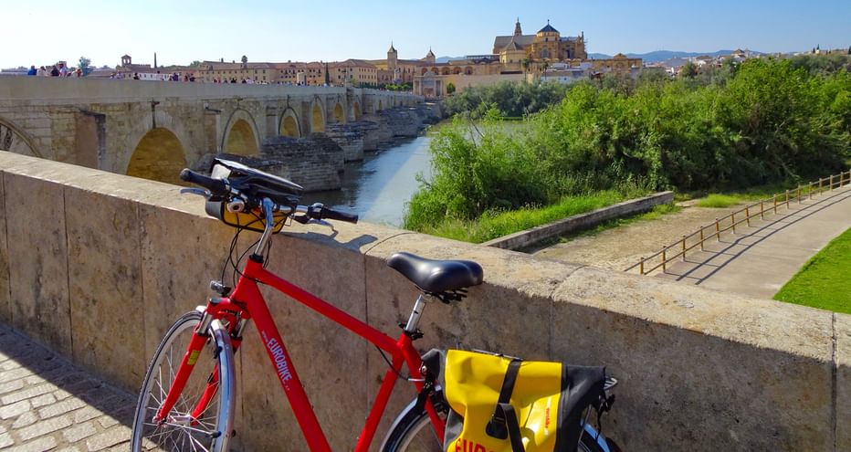 A bicycle leaning against the Roman bridge of Cordoba