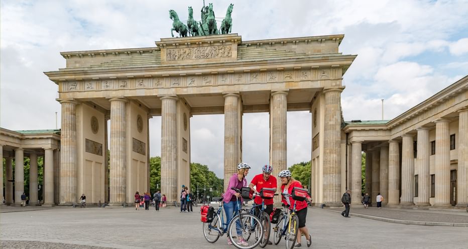 Drei Radfahrer vor dem Brandenburger Tor in Berlin