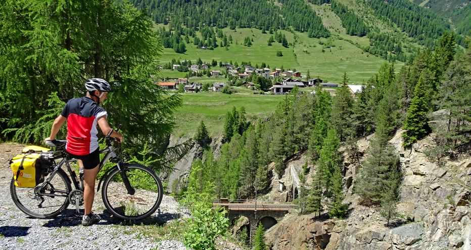 Radpause auf einer Anhöhe mit Blick auf Zernez und einer Eisenbahnbrücke
