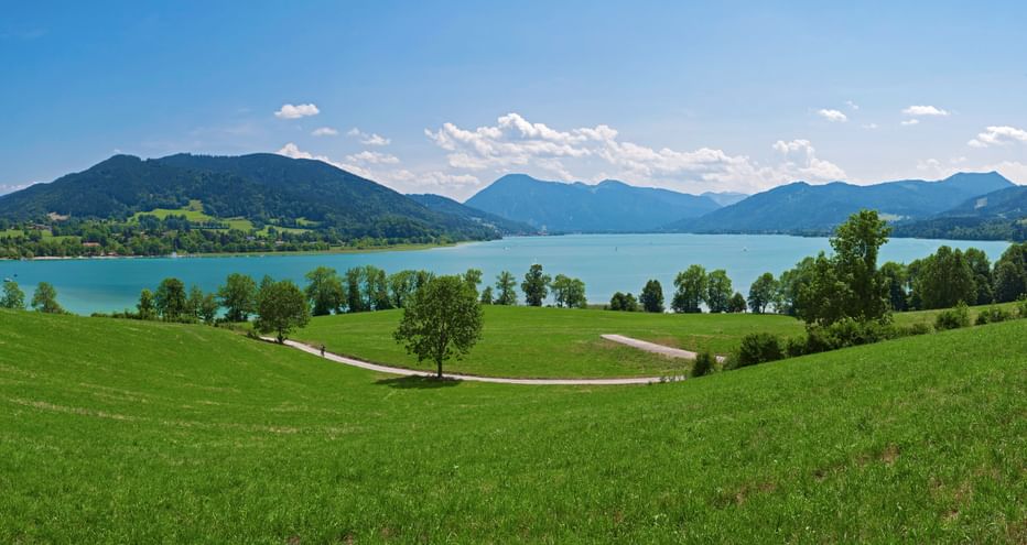 View across meadows to Lake Tegernsee with the mountains in the background