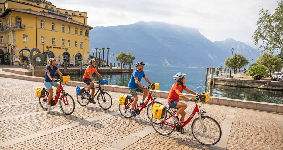 Gruppe von Radfahrern im Zentrum von Riva del Garda mit Seeblick