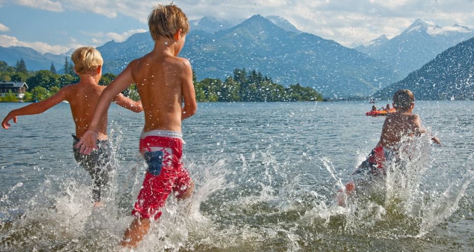 Three children splash in the water in Zeller See