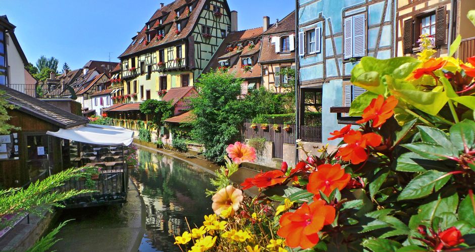 Alte Fachwerkhäuser an der Lauch in Colmar, mit Blumen im Vordergrund