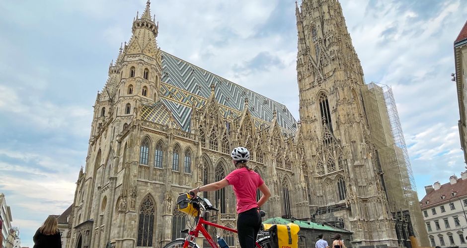Eine Radfahrerin steht vor dem Stephansdom in Wien
