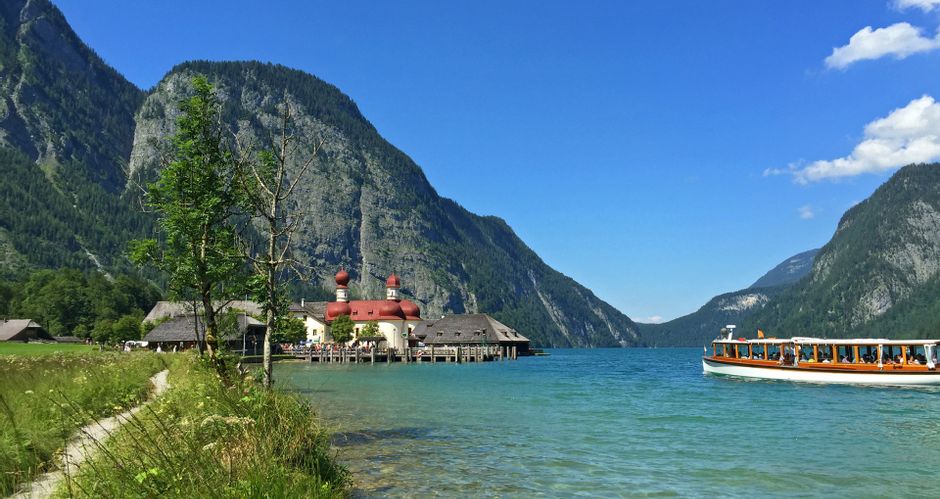 View from the shore of St. Bartholomae on Königssee with a boat and mountains