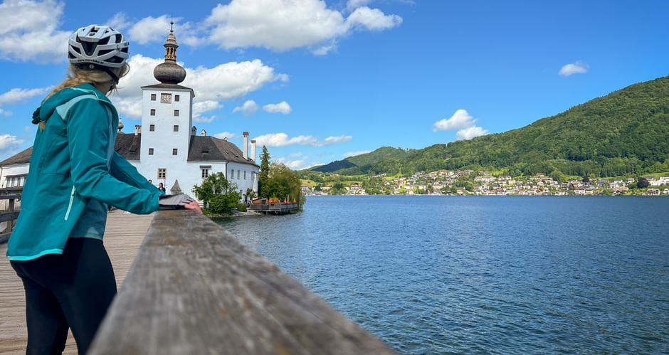Cyclist looks at Ort Castle on Lake Traunsee