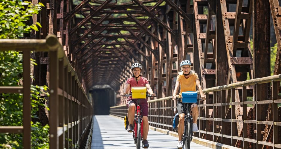Two cyclists on the Ponte di Ferro in the Canal Valley