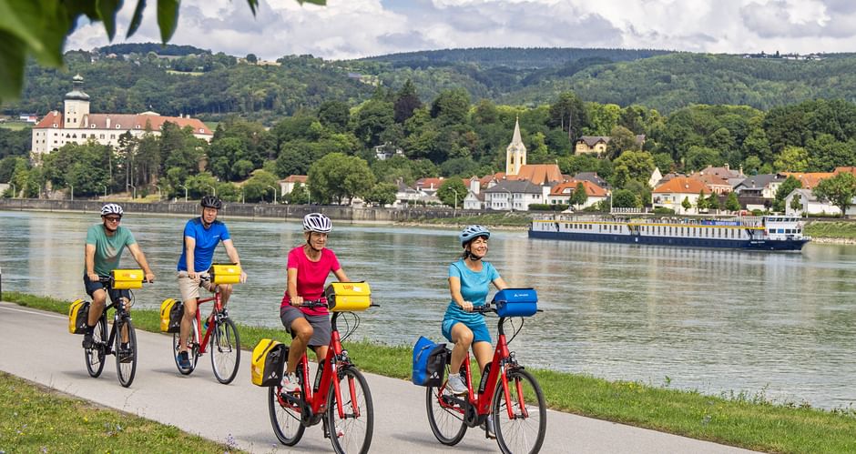 Radfahrer auf Radweg neben der Donau