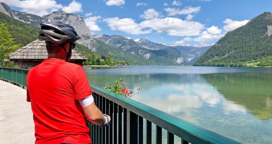 Cyclist enjoying the view of Lake Hallstatt with mountain panorama in the background