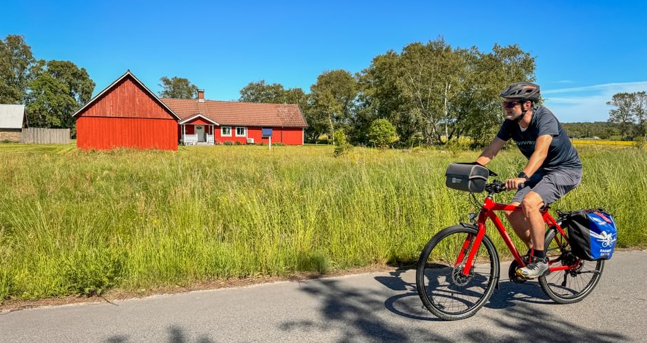Radfahrer auf dem Kattegattleden bei Hjortsberg – mit typischem rotem Schwedenhaus im Hintergrund