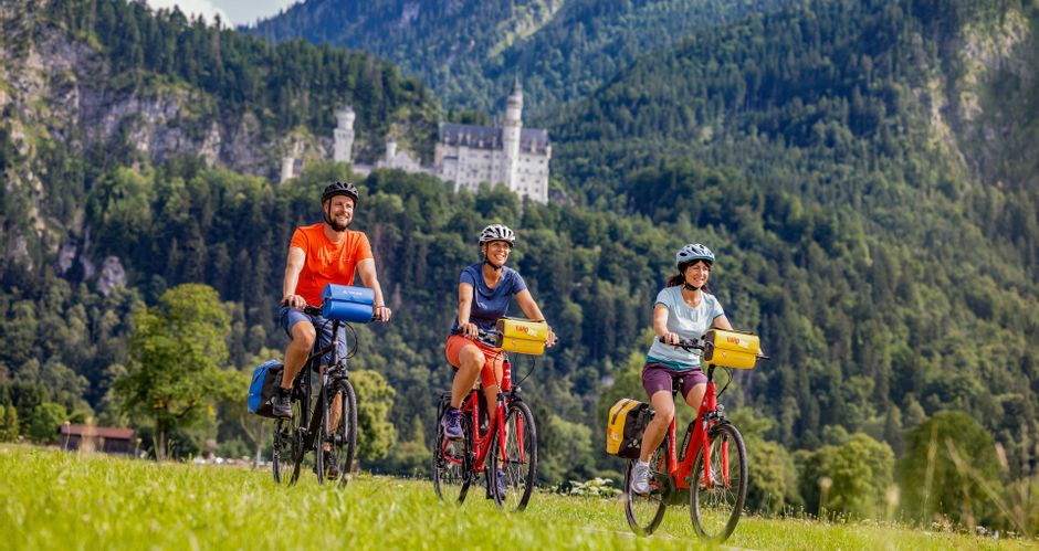 Group of cyclists on the Lech cycle path past Neuschwanstein Castle
