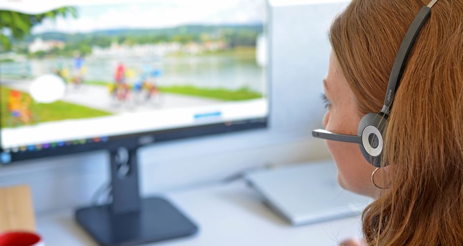 Employee with headset in front of computer