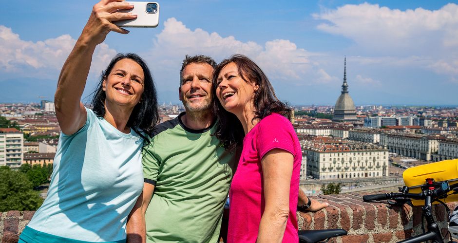 Zwei Frauen und ein Mann machen Selfie in Turin