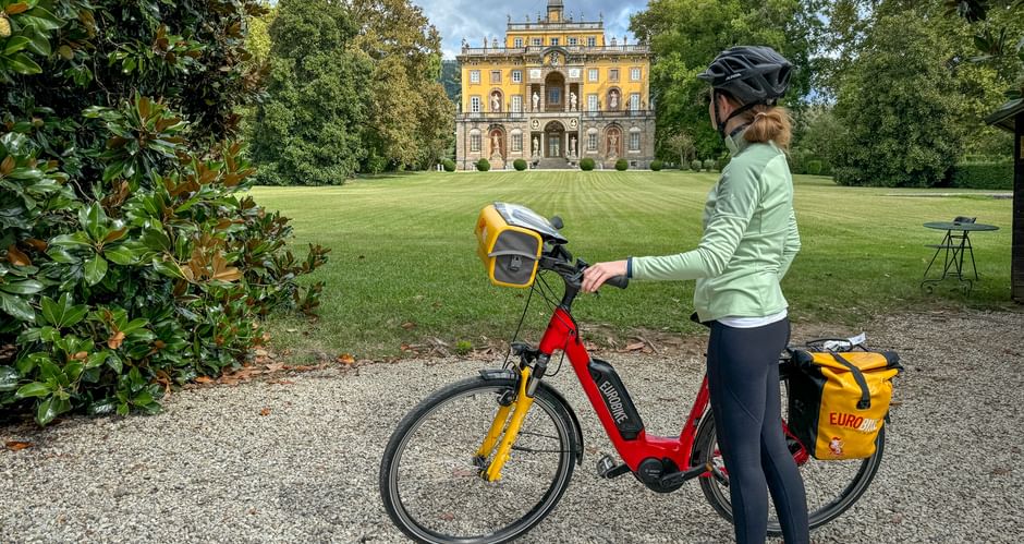 Radfahrerin steht vor der Villa Torrigiani